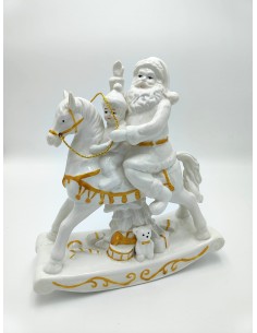 Statua natalizia Babbo Natale su cavallo a dondolo portatore di doni in ceramica bianca ed oro -EVVIVA S.r.l.